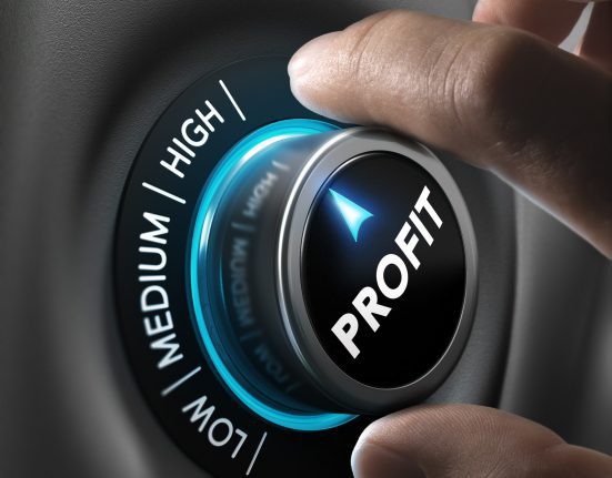 Hand turning a dial labeled PROFIT from medium to high setting, indicating an increase in profit level.