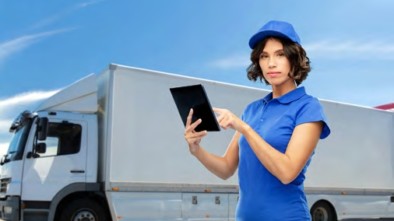Woman holding tablet in front of truck