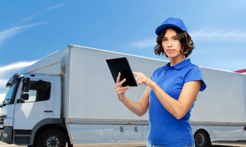Woman holding tablet in front of truck
